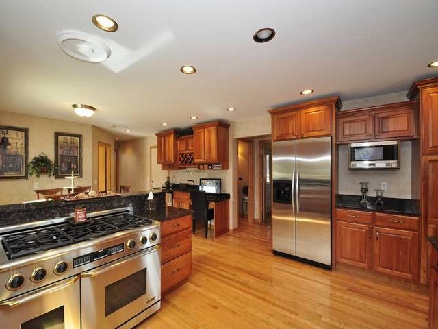 1603 Beech Street Spring Grove, IL 60081 - Photo 8 of 24 a kitchen with stainless steel appliances granite countertop a stove and a refrigerator