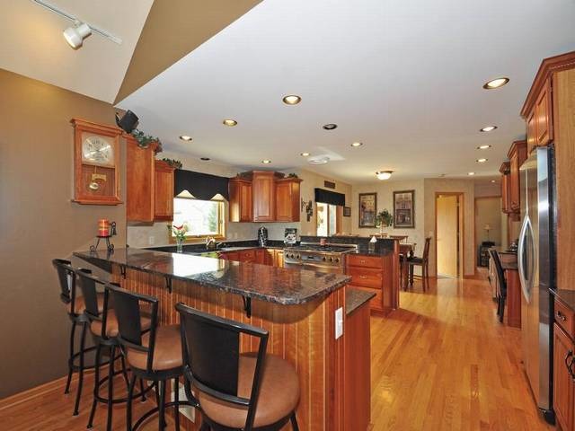 1603 Beech Street Spring Grove, IL 60081 - Photo 9 of 24 a dining hall with stainless steel appliances a dining table and chairs with wooden floor