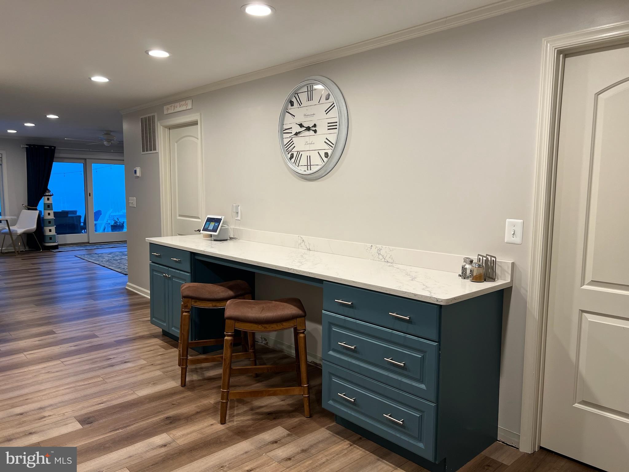 1890 Locust Road Pasadena, MD 21122 - Photo 11 of 53 a room with a table chairs and a clock on wooden floor