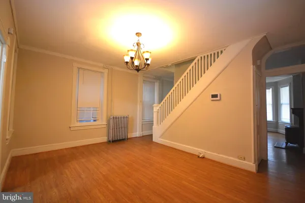 a view of a livingroom with wooden floor and stairs