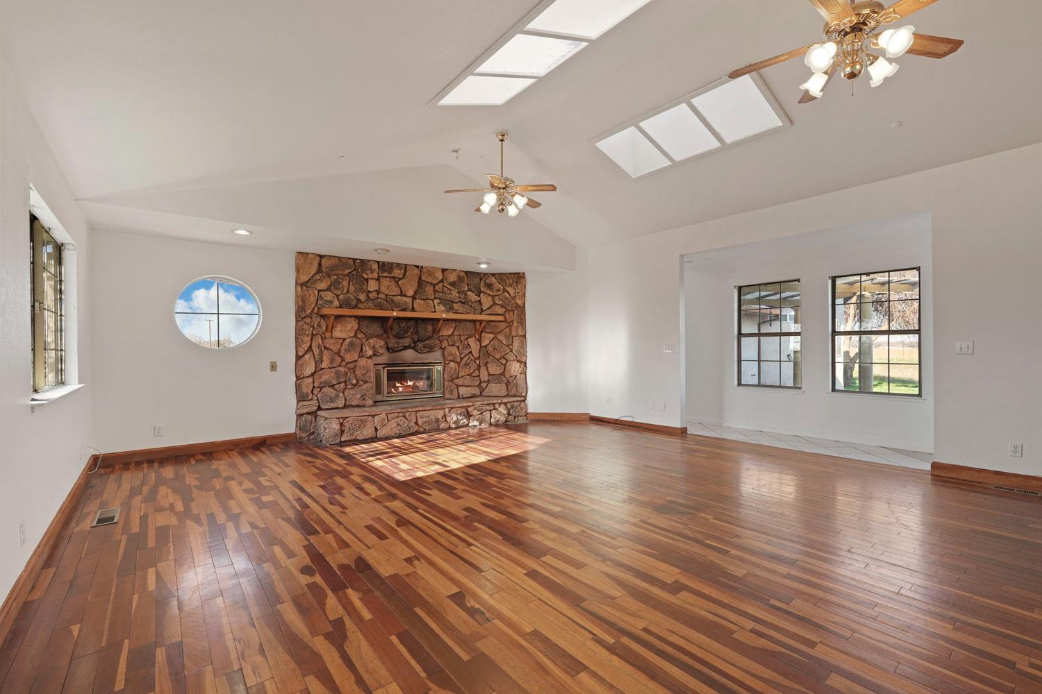 16321 South Wing Levee Road Stockton, CA 95206 - Photo 22 of 71 an empty room with wooden floor chandelier and windows
