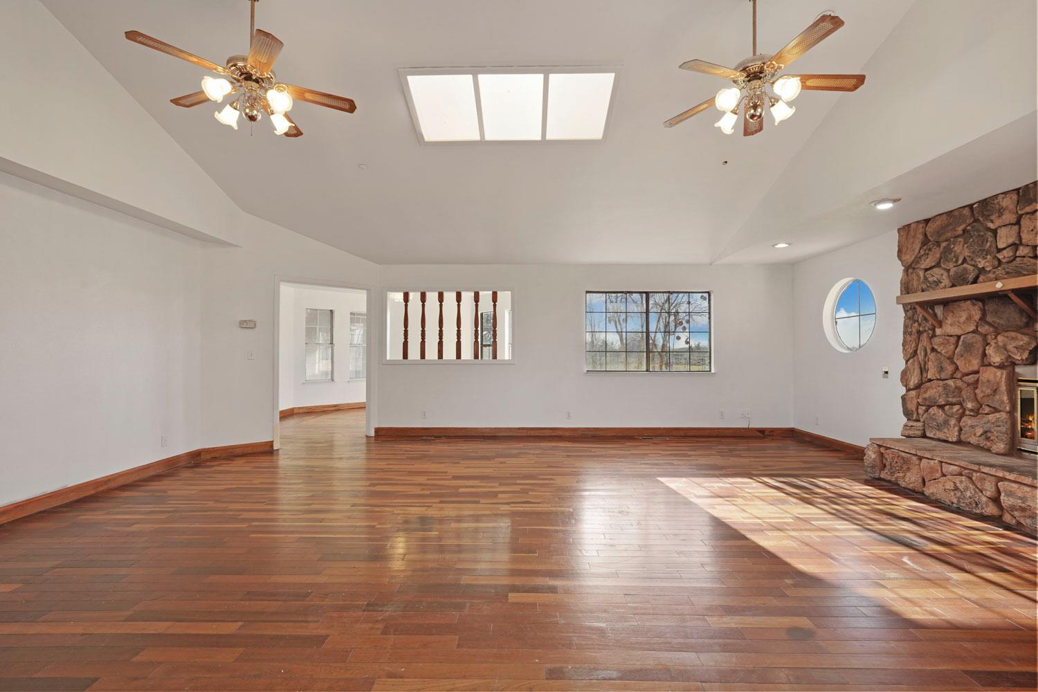 16321 South Wing Levee Road Stockton, CA 95206 - Photo 23 of 71 a view of an empty room with chandelier fan and wooden floor