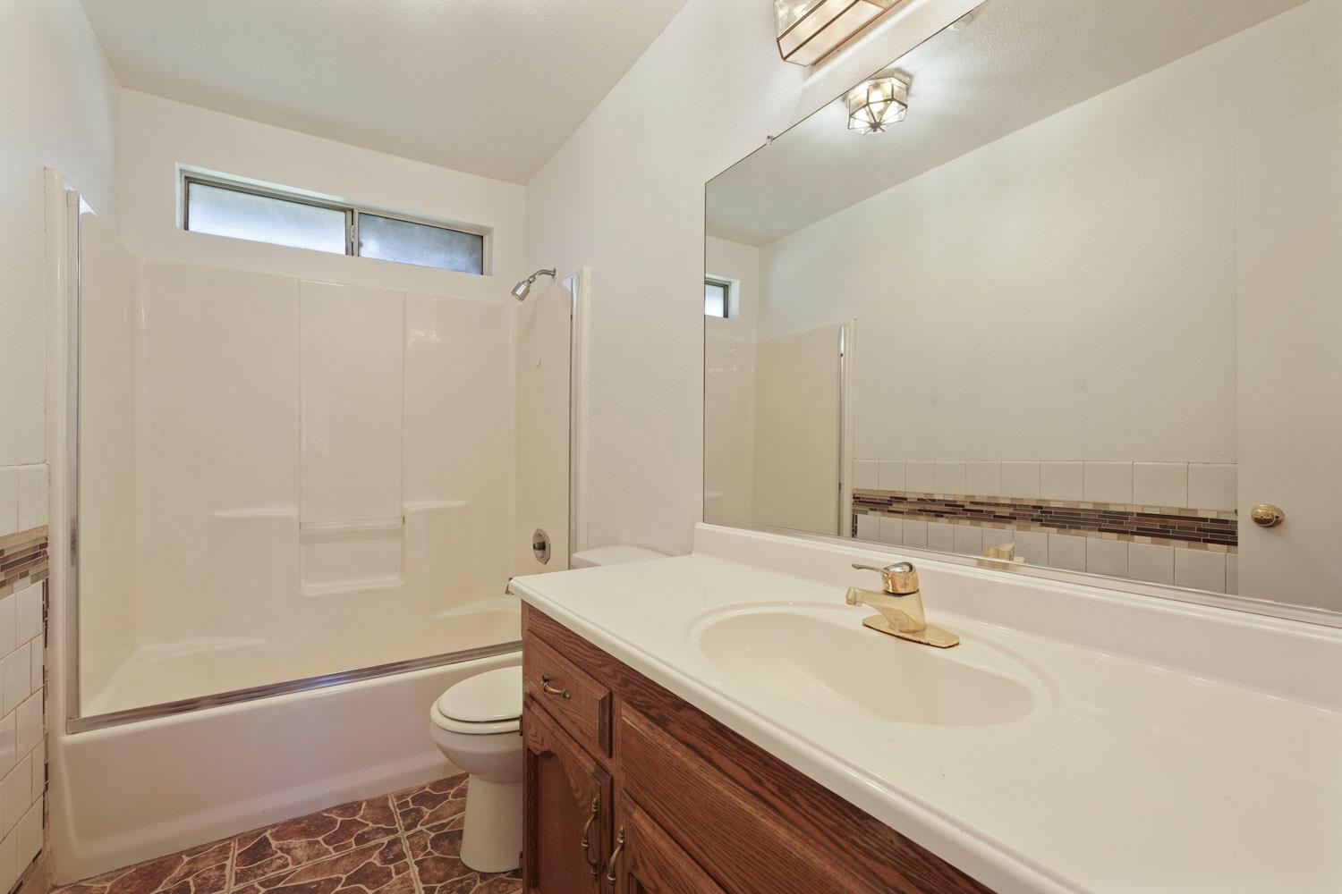 16321 South Wing Levee Road Stockton, CA 95206 - Photo 47 of 71 a bathroom with a sink a toilet a shower and a mirror