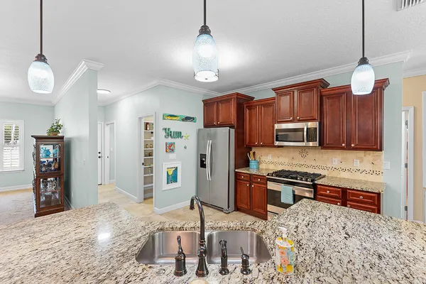 a kitchen with stainless steel appliances granite countertop a sink refrigerator and cabinets