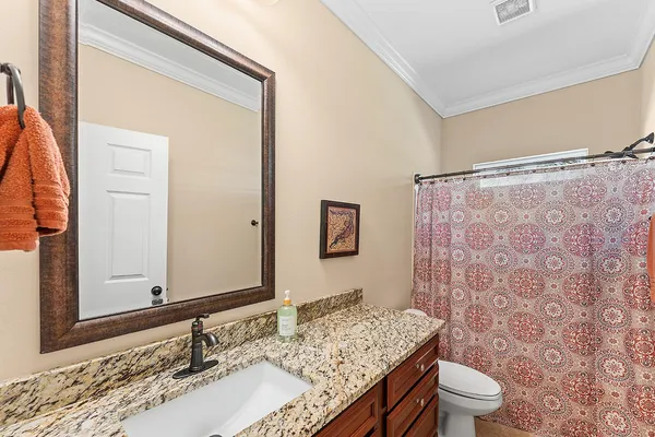 a bathroom with a granite countertop sink toilet and shower