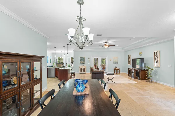 a view of a dining room and livingroom with furniture wooden floor a chandelier