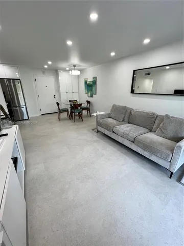 a living room with furniture and a large mirror