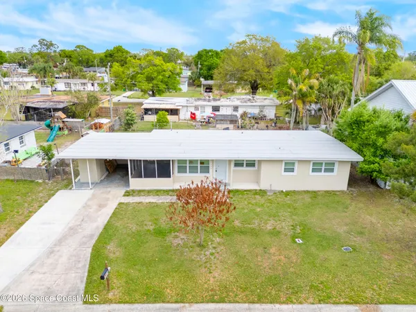 a view of a house with a backyard and a tree