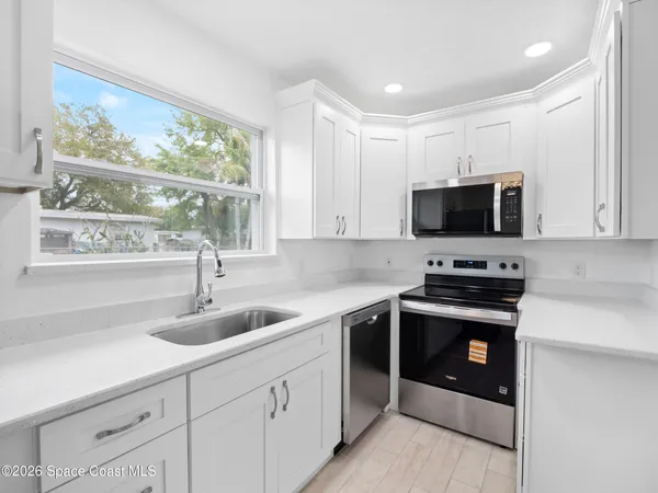 a kitchen with a sink stainless steel appliances and cabinets