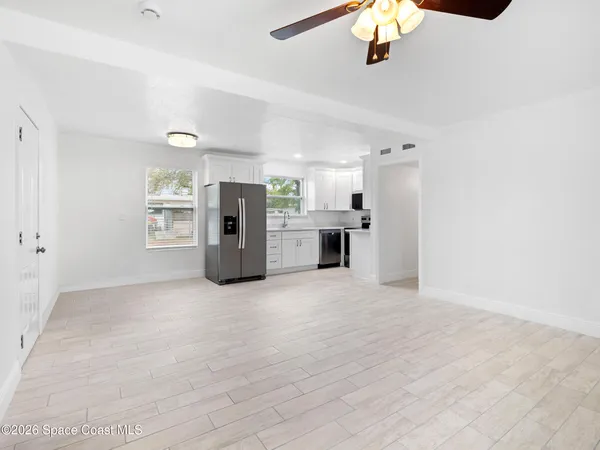 a view of a kitchen with a sink and a refrigerator