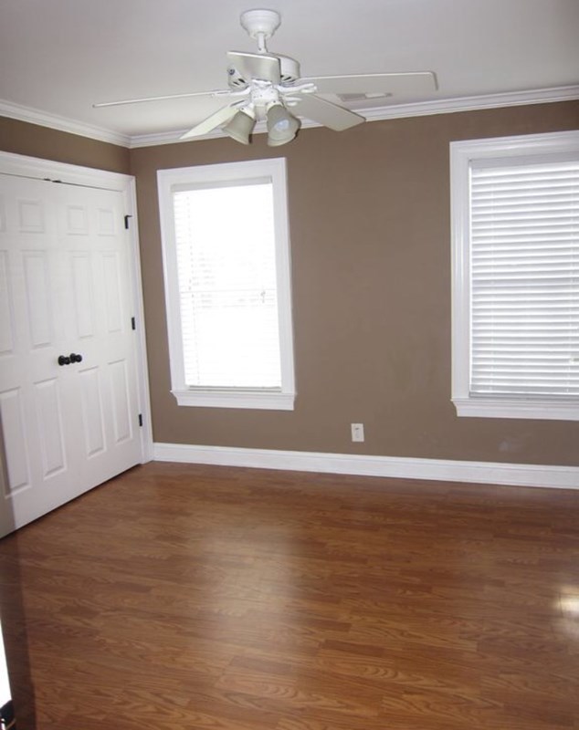 6793 Houston Road Macon, GA 31216 - Photo 16 of 22 an empty room with wooden floor chandelier fan and windows