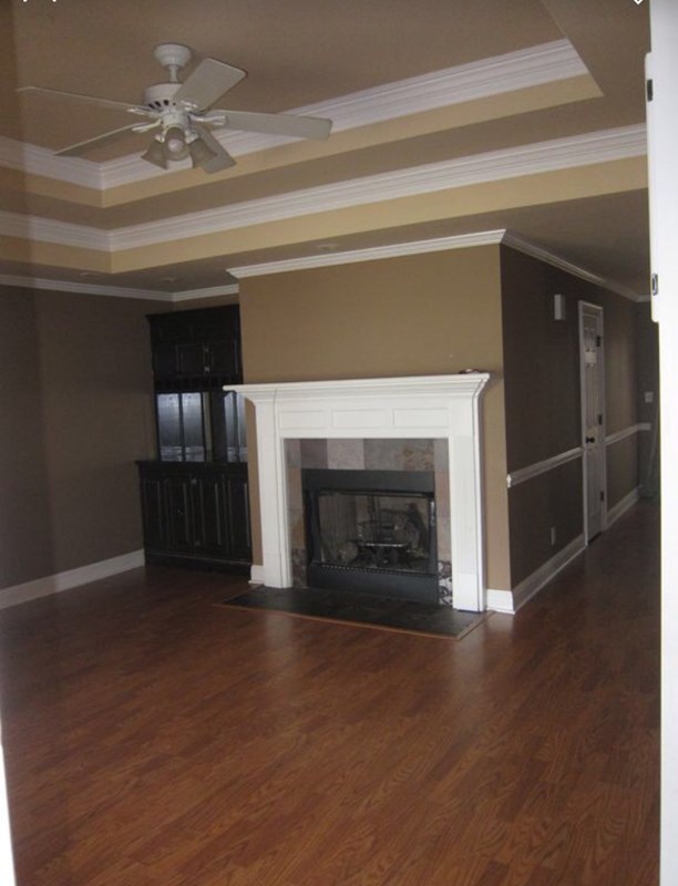 6793 Houston Road Macon, GA 31216 - Photo 7 of 22 an empty room with wooden floor fireplace and windows