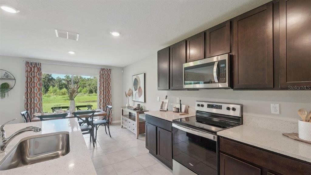 17577 Acorn Drop Road Land O Lakes, FL 34638 - Photo 2 of 23 a kitchen with stainless steel appliances granite countertop a sink stove and cabinets