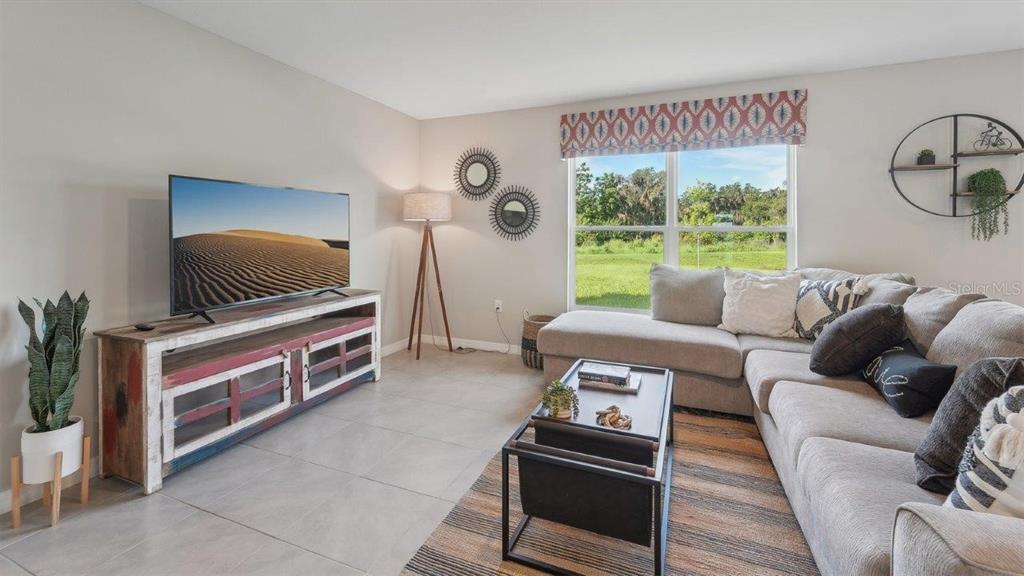 17577 Acorn Drop Road Land O Lakes, FL 34638 - Photo 6 of 23 a living room with furniture a large window and a flat screen tv