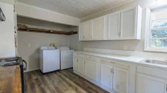 a utility room with cabinets washer and dryer