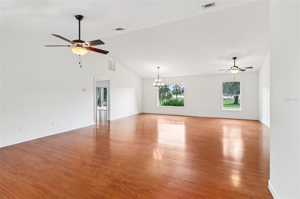 40610 Babb Road Umatilla, FL 32784 - Photo 11 of 45 a view of a room with wooden floor a ceiling fan and windows
