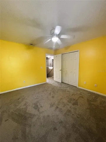 a view of a big room with windows and chandelier fan