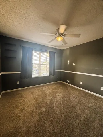 a view of an empty room with a ceiling fan