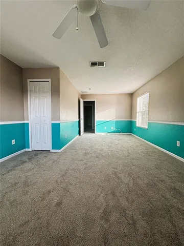 a view of empty room with window and ceiling fan