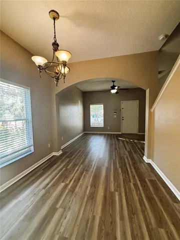 a view of a room with a wooden floor and chandelier