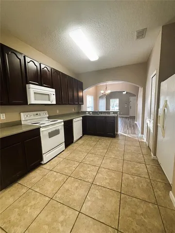 a large kitchen with stainless steel appliances granite countertop a stove a sink dishwasher and a refrigerator