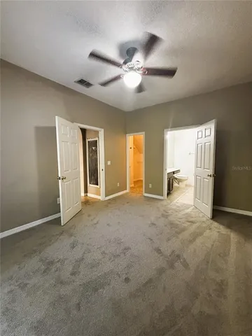 an empty room with windows and fan