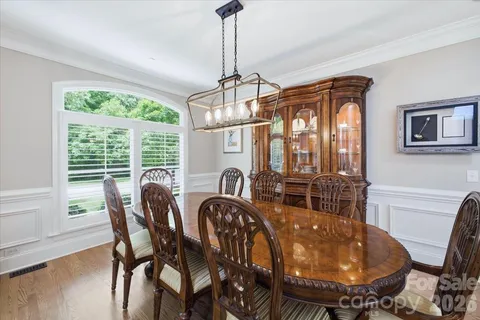 a dining room with furniture a chandelier and wooden floor