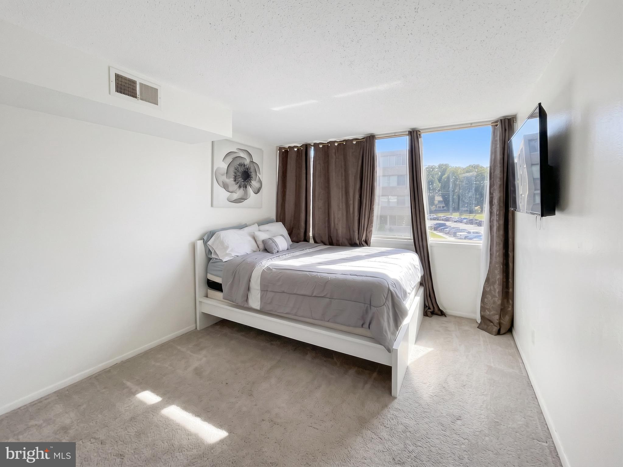 1822 Metzerott Road, Unit 401 Hyattsville, MD 20783 - Photo 11 of 22 a bedroom with a bed window and flat screen tv