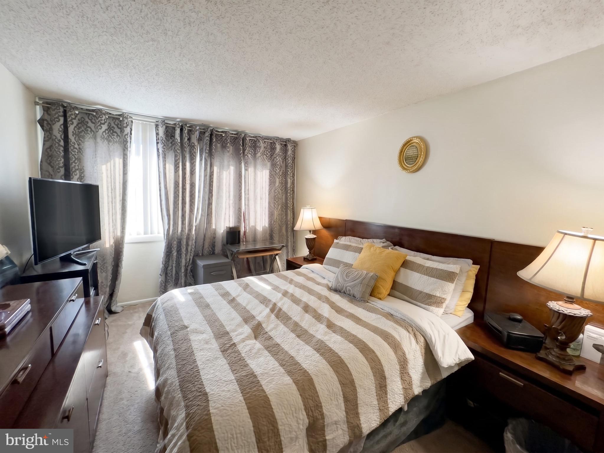 1822 Metzerott Road, Unit 401 Hyattsville, MD 20783 - Photo 13 of 22 a bedroom with a bed and a flat screen tv