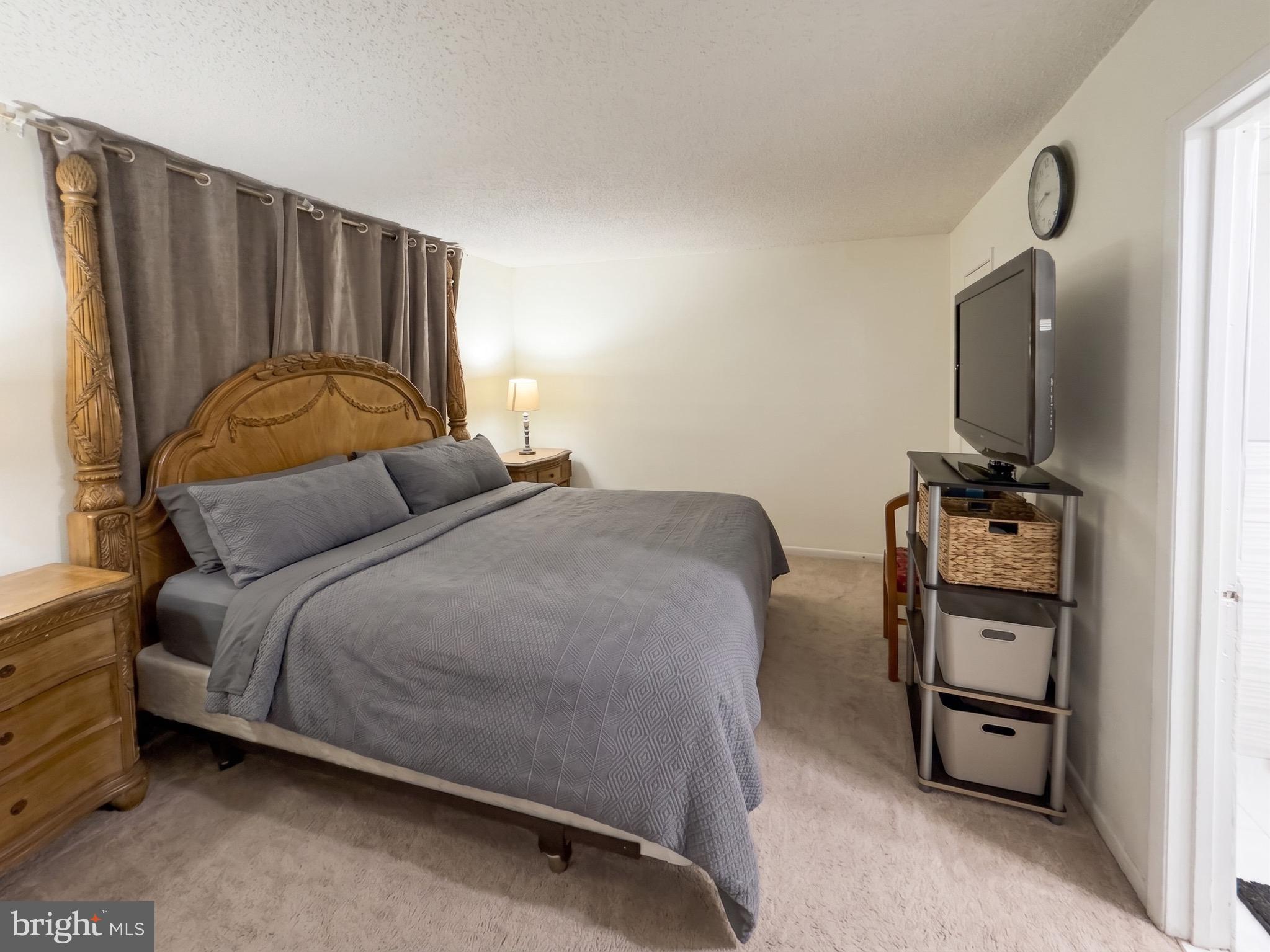 1822 Metzerott Road, Unit 401 Hyattsville, MD 20783 - Photo 15 of 22 a bedroom with a bed and a flat tv screen on a dresser