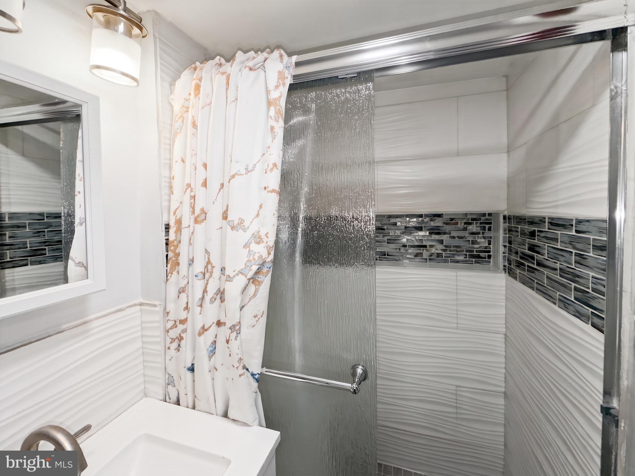 1822 Metzerott Road, Unit 401 Hyattsville, MD 20783 - Photo 18 of 22 a bathroom with a shower curtain and a sink