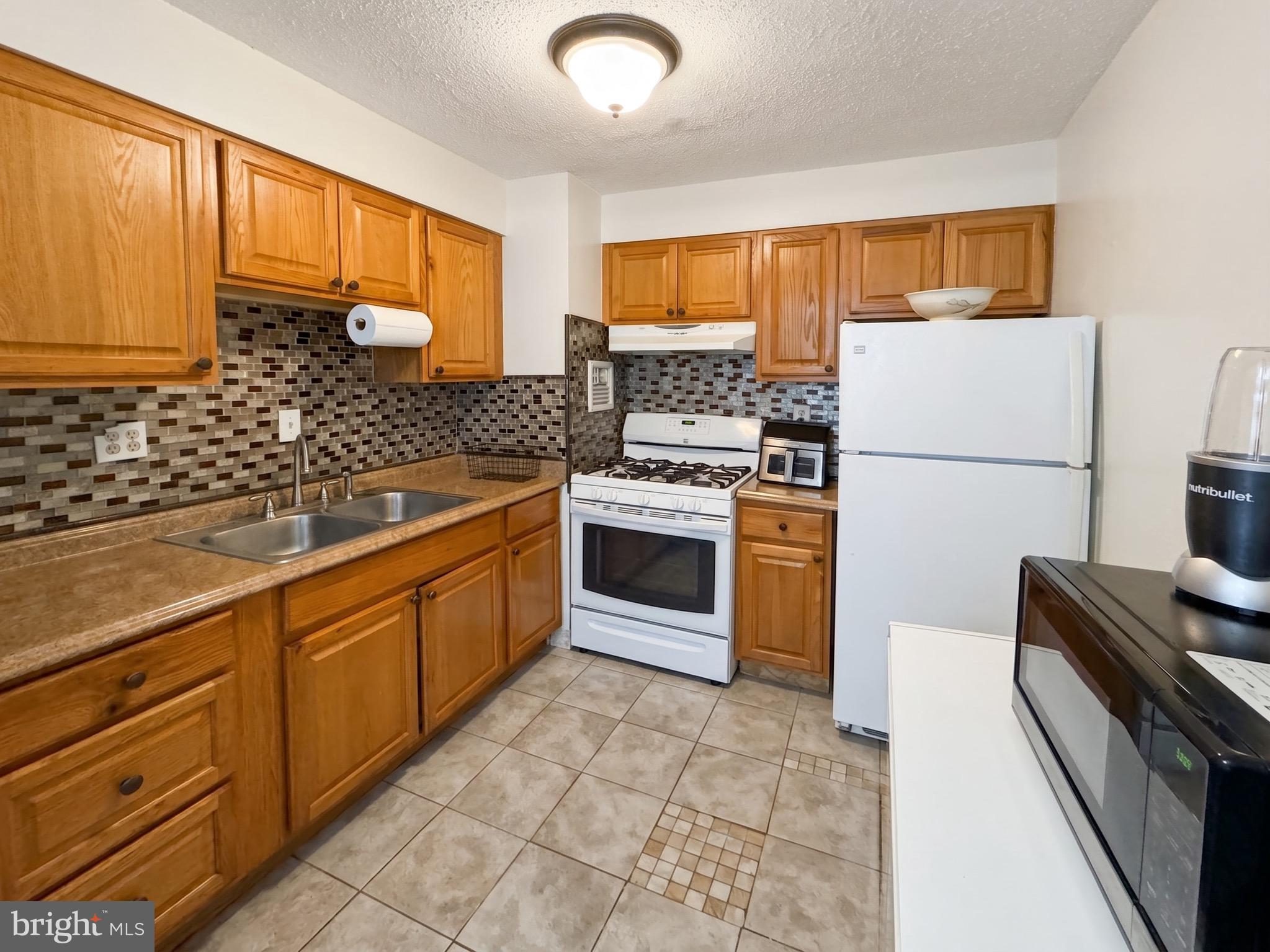 1822 Metzerott Road, Unit 401 Hyattsville, MD 20783 - Photo 8 of 22 a kitchen with a stove sink and refrigerator