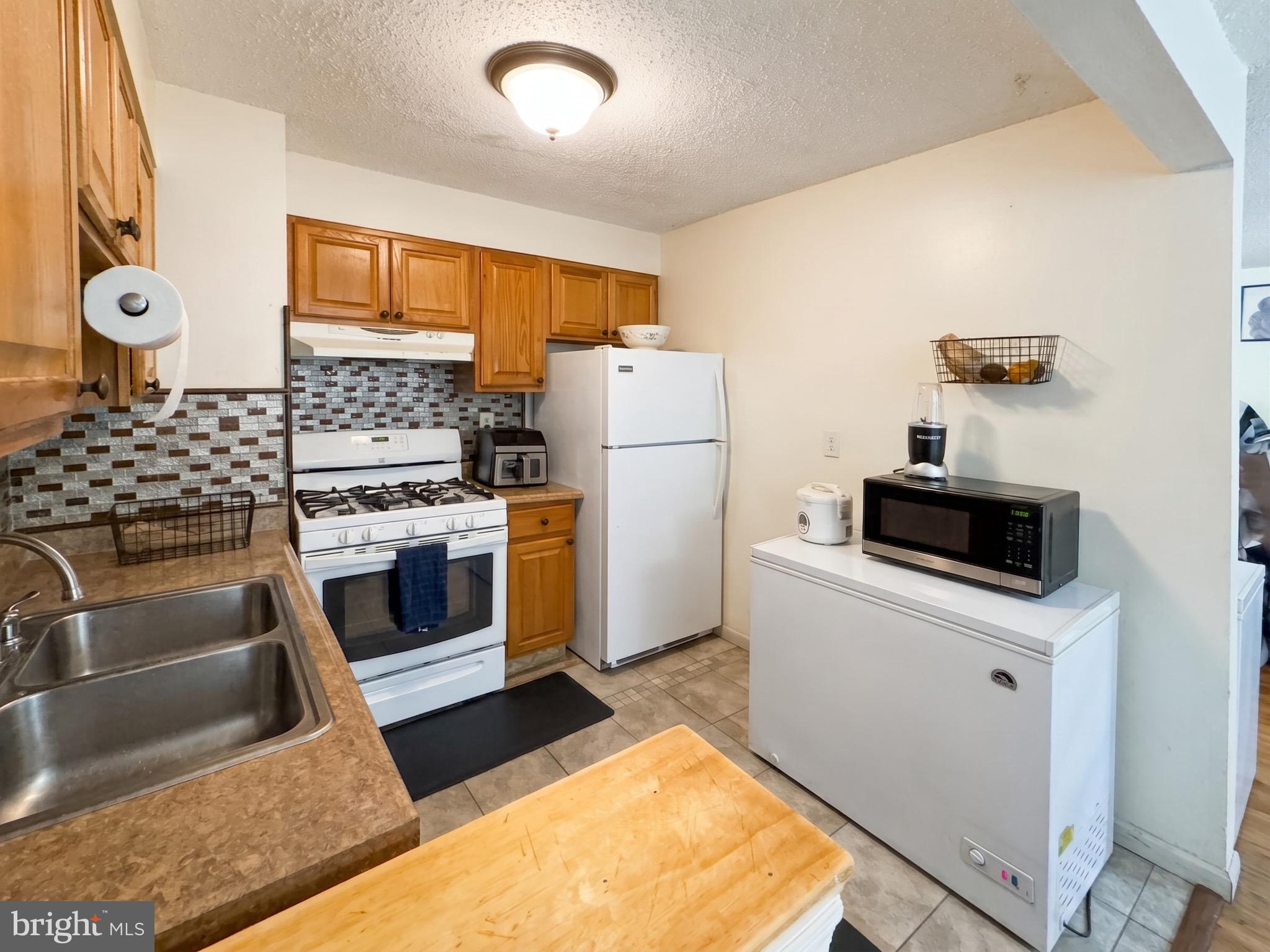 1822 Metzerott Road, Unit 401 Hyattsville, MD 20783 - Photo 9 of 22 a kitchen with stainless steel appliances a stove a sink and a refrigerator
