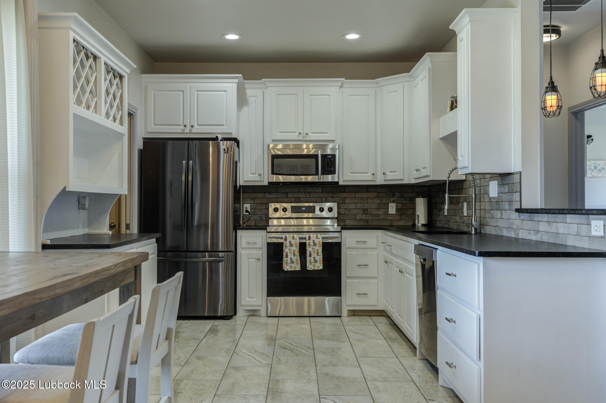 5218 Lehigh Street Lubbock, TX 79416 - Photo 17 of 39 a kitchen with granite countertop a refrigerator and a stove top oven