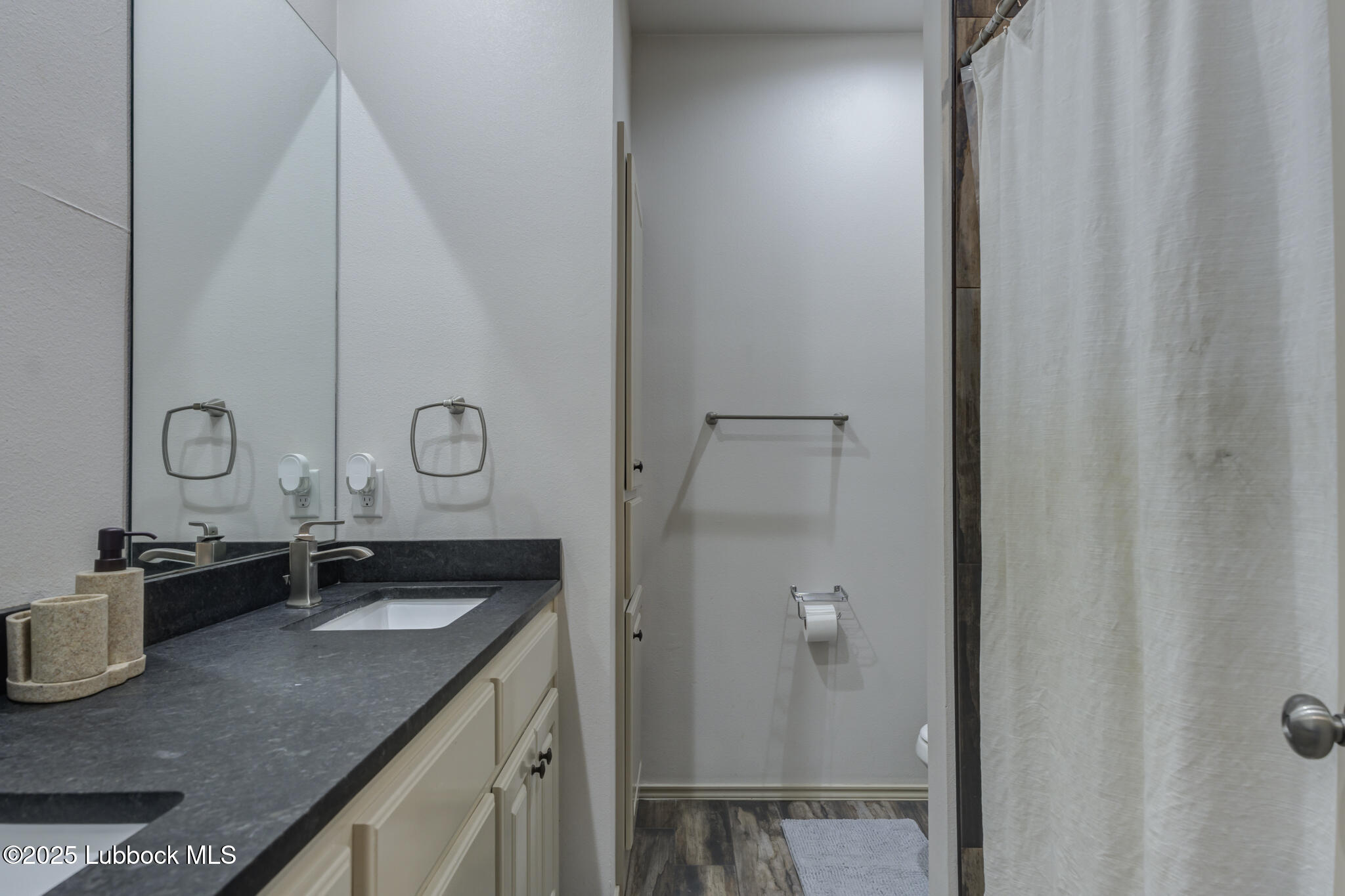 5218 Lehigh Street Lubbock, TX 79416 - Photo 32 of 39 a bathroom with a granite countertop sink and a mirror