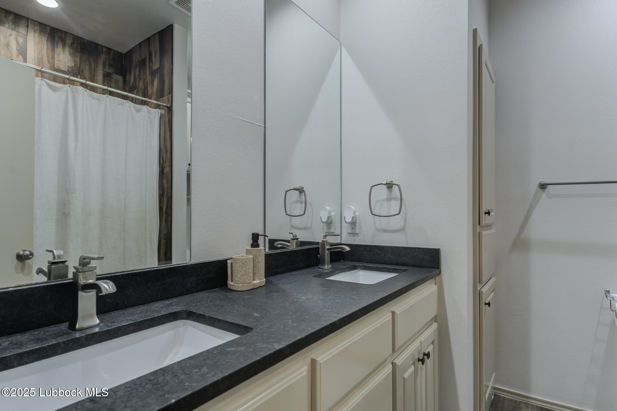 5218 Lehigh Street Lubbock, TX 79416 - Photo 33 of 39 a bathroom with a double vanity sink and a mirror