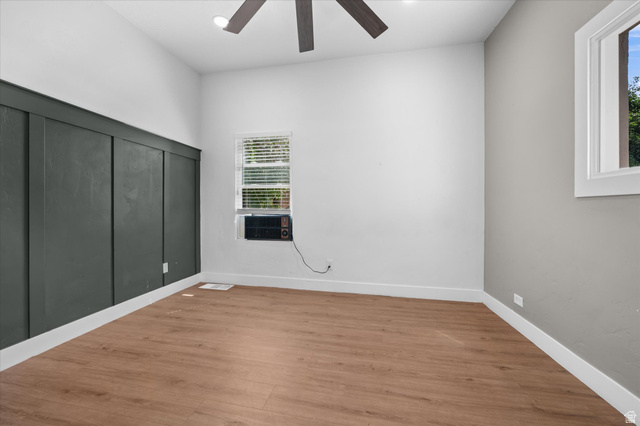327 35th Street Ogden, UT 84401 - Photo 21 of 31 Room featuring wood-finish flooring, a contemporary ceiling fan, and a prominent dark accent wall with vertical paneling