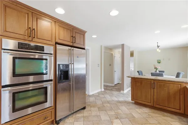 a kitchen with stainless steel appliances a refrigerator and a stove top oven