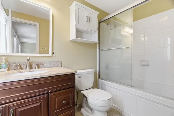 a bathroom with a granite countertop sink toilet and shower