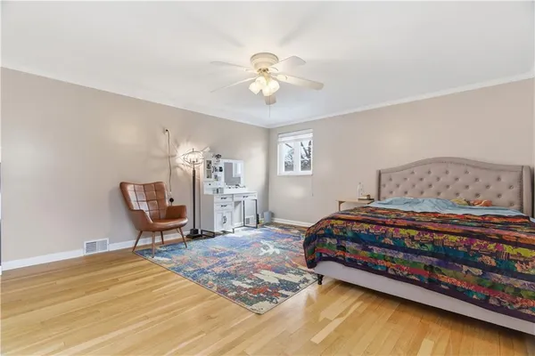 a bedroom with a bed a chair and a chandelier