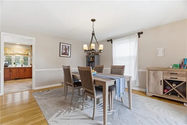 a dining room with furniture a chandelier and wooden floor