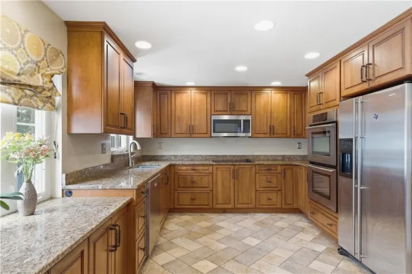 a kitchen with stainless steel appliances granite countertop a sink stove and refrigerator