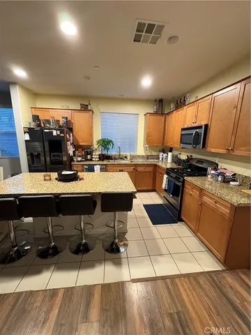 a kitchen with stainless steel appliances kitchen island granite countertop a sink and counter space