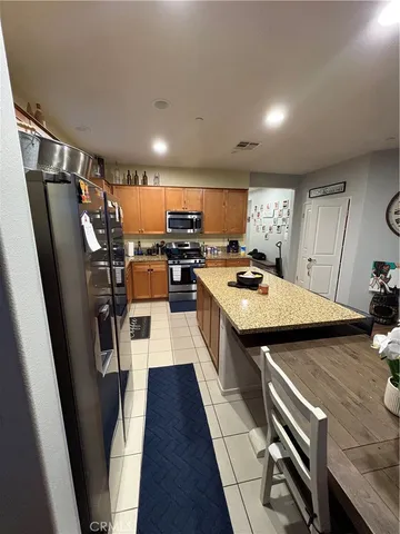 a kitchen with stainless steel appliances a stove a refrigerator and a dining table