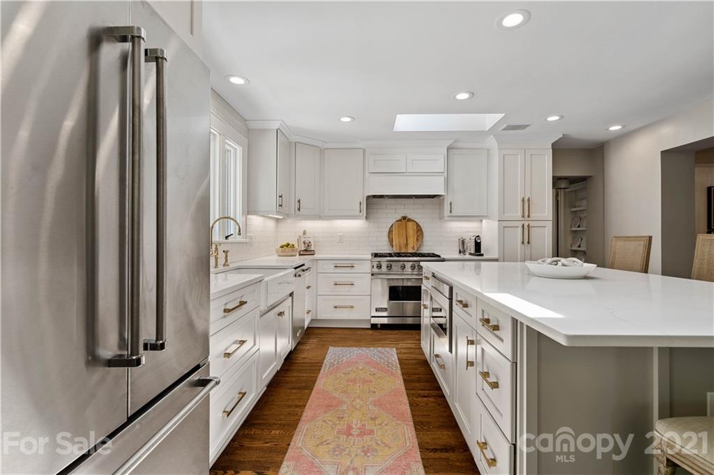 1305 Lilac Road Charlotte, NC 28209 - Photo 2 of 47 a kitchen with kitchen island a stove a sink and a refrigerator