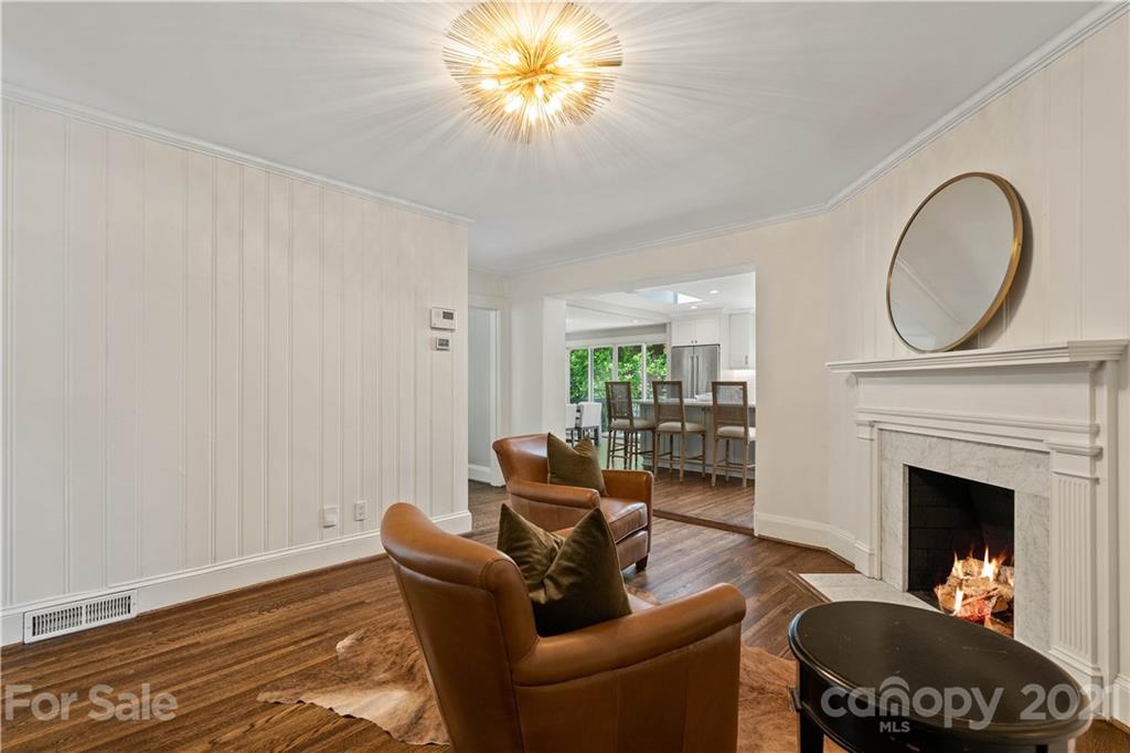 1305 Lilac Road Charlotte, NC 28209 - Photo 17 of 47 a living room with furniture a fireplace and a chandelier