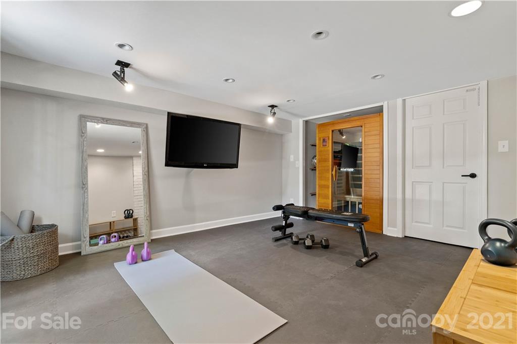 1305 Lilac Road Charlotte, NC 28209 - Photo 30 of 47 a room with gym equipment and a flat screen tv