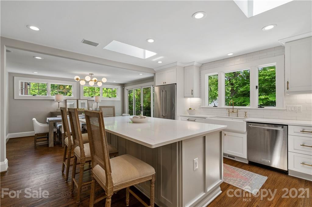 1305 Lilac Road Charlotte, NC 28209 - Photo 4 of 47 a kitchen with a table chairs sink and wooden floor