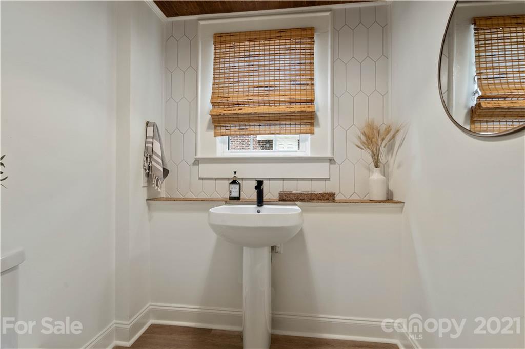 1305 Lilac Road Charlotte, NC 28209 - Photo 32 of 47 a bathroom with a sink a mirror and a window