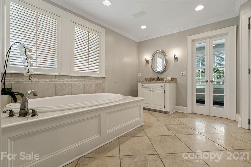 1305 Lilac Road Charlotte, NC 28209 - Photo 10 of 47 a spacious bathroom with a sink a mirror and a bathtub